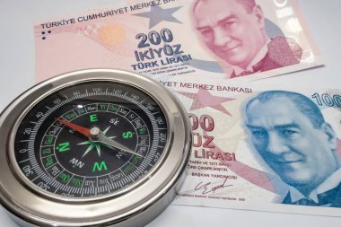 İstanbul, Türkiye-6 Ocak 2022. Para istikameti. Para ve döviz borsası. Kağıt banknotları kapatın ve beyaz arka planda pusula kurun..