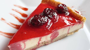 Beyaz tabakta ahududulu cheesecake yemeye hazır.