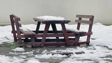 Doğada kar altında park bankında