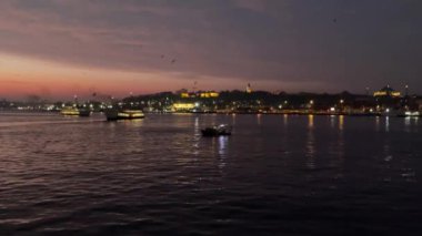 İstanbul, Türkiye - 17 Mart 2022 Gün doğumu ve İstanbul ve Galata Köprüsü 'nden feribot ve botlarla eski kent manzarası
