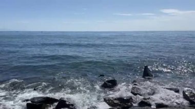 Bahar mevsiminde dalgalı deniz kıyısı, uçurum ve deniz manzarası