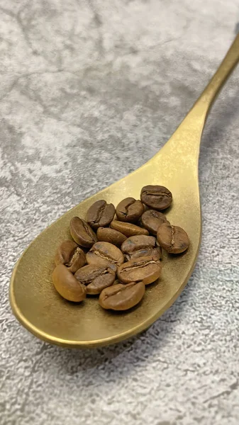 Close Roasted Coffee Beans Metal Spoon Gray Background — Zdjęcie stockowe