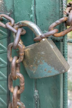 Paslı ve eski kilitli metal kapı. asma kilit ve zincir