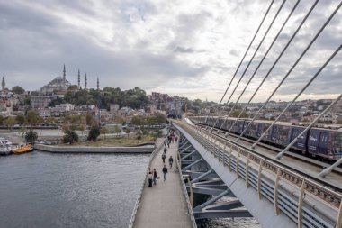 Golden Horn, istanbul, Türkiye. Sonbahar mevsiminde Golden Horn metro köprüsünün manzarası ve gezginler ve turistler için bulutlu bir gün..