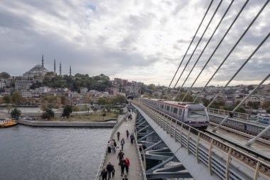 Golden Horn, istanbul, Türkiye. Sonbahar mevsiminde Golden Horn metro köprüsünün manzarası ve gezginler ve turistler için bulutlu bir gün..