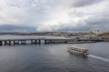 Golden Horn, istanbul, Türkiye. Sonbahar mevsiminde Golden Horn metro köprüsünün manzarası ve gezginler ve turistler için bulutlu bir gün..