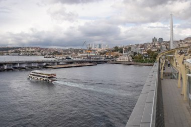 Golden Horn, istanbul, Türkiye. Sonbahar mevsiminde Golden Horn metro köprüsünün manzarası ve gezginler ve turistler için bulutlu bir gün..
