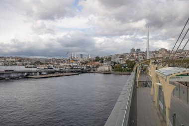 Golden Horn, istanbul, Türkiye. Sonbahar mevsiminde Golden Horn metro köprüsünün manzarası ve gezginler ve turistler için bulutlu bir gün..