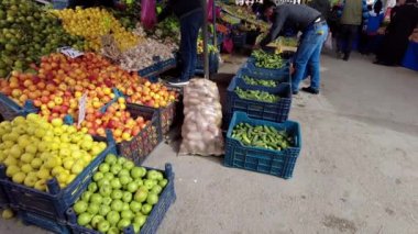 Meyve ve sebzelerin fiyatları pazardaki tezgahın üzerine dizilmişti.,