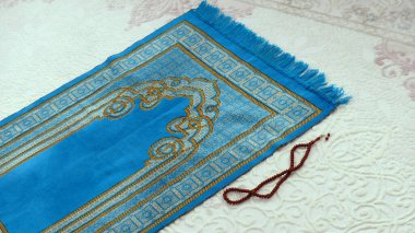 İbadet halısı ve tespih, İslam 'da namaz kılmak için kullanılan mavi dua halısı.,