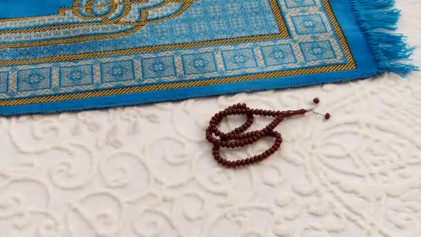 イスラームでの礼拝に使われる青の礼拝用絨毯とロザリオ — ストック動画