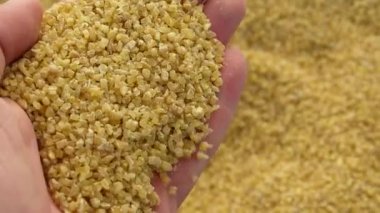 buğdaydan yapılma bulgur ve bir insan bulgur 'a dokunur.,