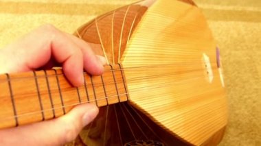 Bir müzisyen elinde saz, Türk enstrümanları, yakın plan baglama, saz tutuyor.