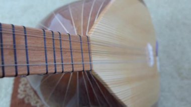 Bir müzisyen elinde saz, Türk enstrümanları, yakın plan baglama, saz tutuyor.