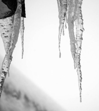 Çatıda buz saçakları, kar yağıyor, sert bir kış.,