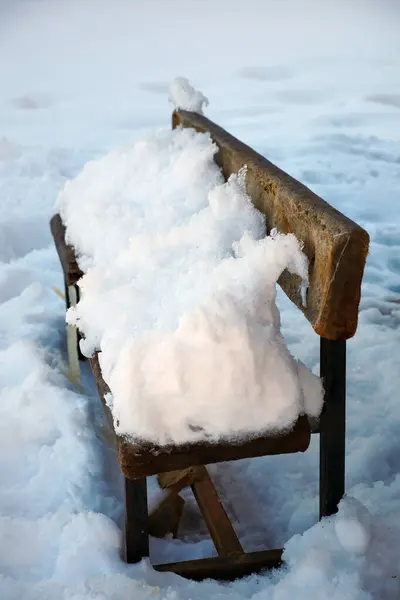 a lot of snow fell on the sitting bench, snow and sitting bench,