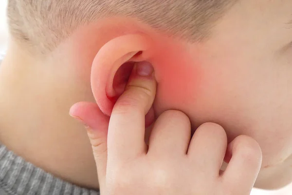 Kulak ağrısı, kulağını tutan bir çocuk, kulak ağrısı, kulak iltihabı olan bir çocuk.,