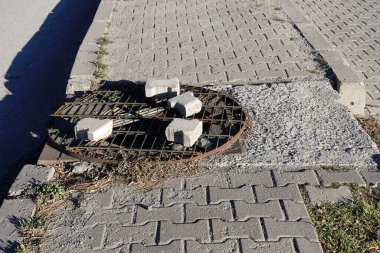 Bir kaldırım kapağı, demir lağım kapağı, yol kenarında güvenlik önlemleri alınmamış..