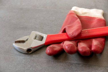 İş güvenliği için, eldivenlerle çalışmak gereklidir, bir ingiliz anahtarı, kalın plastik eldivenler yerde duruyordur.,