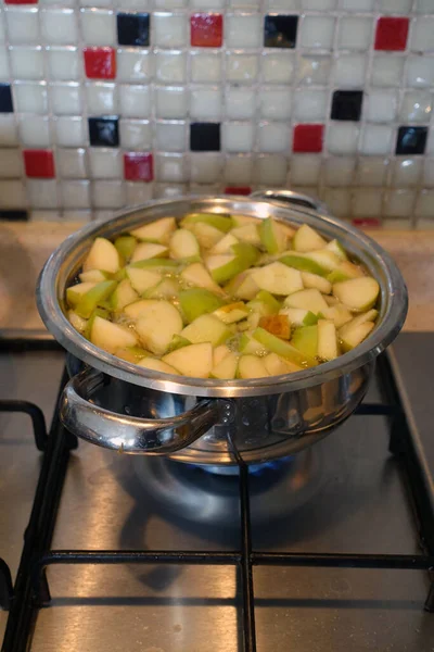 りんごのコンポートとみじん切りにしたりんごを鍋に入れて自家製のりんごジュースを作る — ストック写真