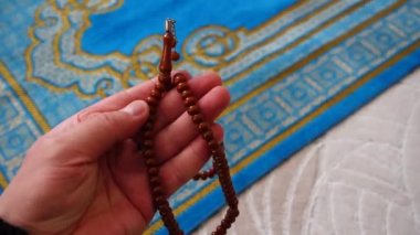 Mavi bir kilim, bir Müslüman 'ın evinde, onun tespihi, hemen yanında, İslam' da ibadet için bir dua, bir halı.,