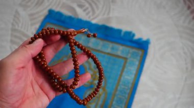Mavi bir kilim, bir Müslüman 'ın evinde, onun tespihi, hemen yanında, İslam' da ibadet için bir dua, bir halı.,