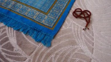 Mavi bir kilim, bir Müslüman 'ın evinde, onun tespihi, hemen yanında, İslam' da ibadet için bir dua, bir halı.,
