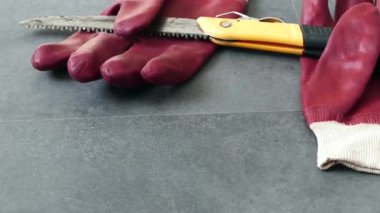 İş güvenliği için, eldivenlerle çalışmak gereklidir, bir el testeresi ve yerde kalın plastik eldivenler vardır.,