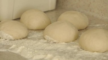 Hamur parçaları, çörek yapmak için hamur yuvarlayan biri.,