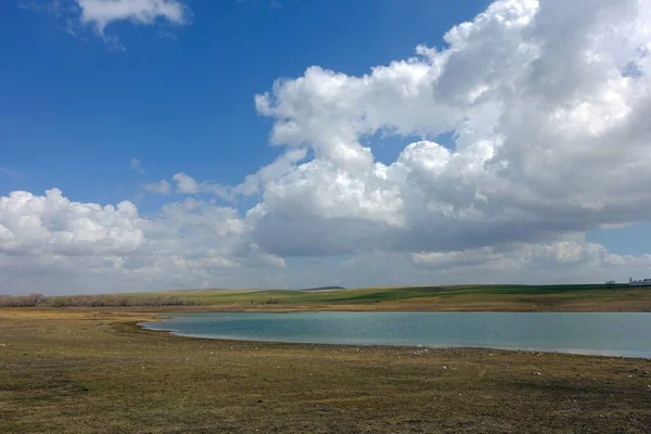 İlkbaharın gelişi ve uyanan doğa manzarası göl ve bulutlar.