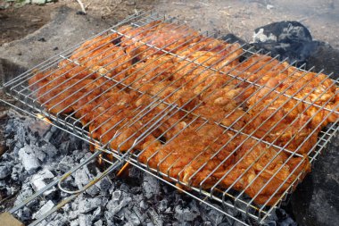Piknikte mangalın tadını çıkarıyorum. Mangalda tavuk pirzolası pişiyor.,