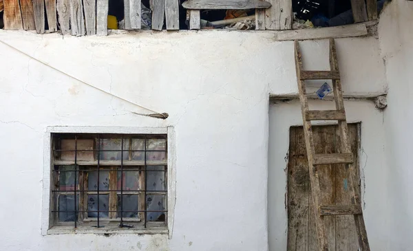 Eski köy evi ve çatısına yerleştirilmiş tahta merdiven.,
