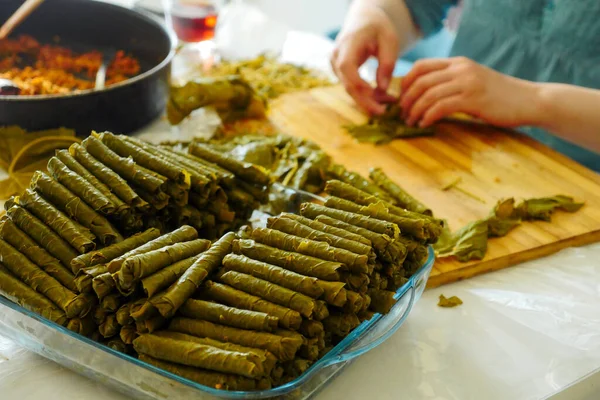 a cook making stuffed leaves, making stuffed leaves at home, stuffed leaves from Turkish cuisine,