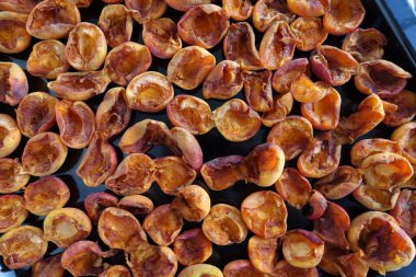 drying apricots in a metal tray on the balcony of the house, drying apricots in the sun, natural fruit drying process,
