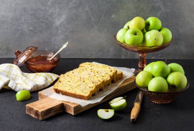 Dilimlenmiş elma ve hindistancevizli hödük, arka planda tahta kesme tahtasının üzerinde.