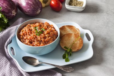 Mavi kasede patlıcan havyarı ve arka planda taze sebzeler..