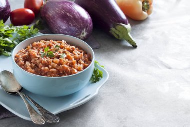 Mavi kasede patlıcan havyarı ve arka planda taze sebzeler. Boşluğu kopyala