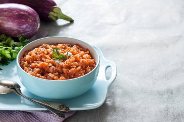 Mavi kasede patlıcan havyarı ve arka planda taze sebzeler. Boşluğu kopyala