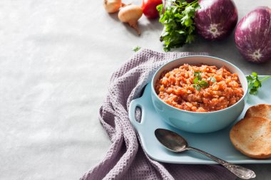 Mavi kasede patlıcan havyarı ve arka planda taze sebzeler. Boşluğu kopyala