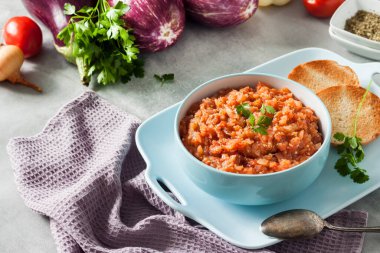 Mavi kasede patlıcan havyarı ve arka planda taze sebzeler..