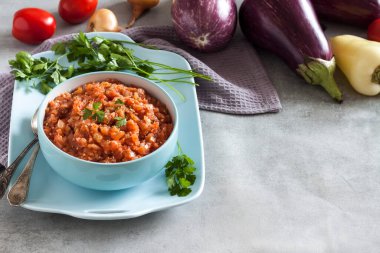 Mavi kasede patlıcan havyarı ve arka planda taze sebzeler. Boşluğu kopyala