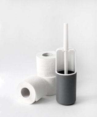 Beyaz ve gri plastik tuvalet fırçası ve beyaz arka planda tuvalet kağıdı. Boşluğu kopyala