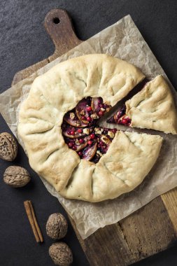 Elmalı ev yapımı galette turtası, yaşlı böğürtlen ve taşralı koyu arkaplanlı taze ahududu ile süslenmiş ceviz. Üst manzara, düz uzanma