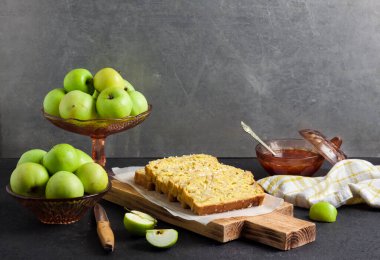 Dilimlenmiş elma ve hindistan cevizli hödük keki, arka planda tahta kesme tahtasının üzerinde. Boşluğu kopyala