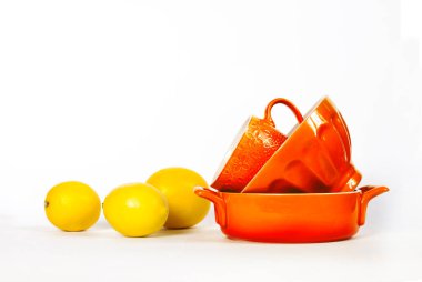 Kitchen and kitchenware. Yellow ceramic crockery tableware with fresh lemons isolated on white background. Copy space