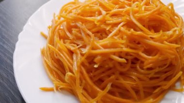 Beyaz tabakta vejetaryen havuç salatası.