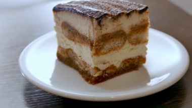 Beyaz tabakta terli mascarpone tiramisu keki.