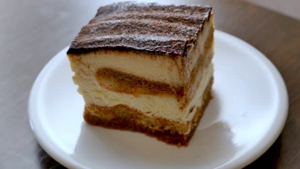 Schwitzen Mascarpone-Tiramisu-Kuchen auf einem weißen Teller — Stockvideo