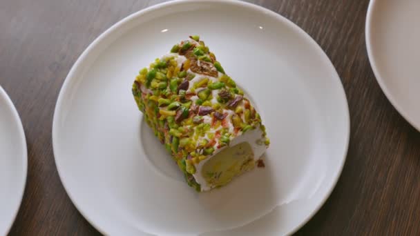 Сладкий фисташковый десерт на белой тарелке — стоковое видео