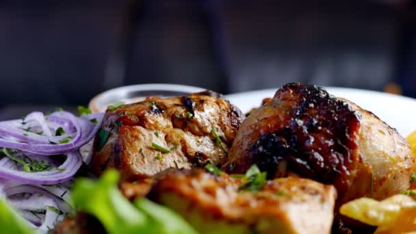 Trozos de carne a la parrilla con patatas y hierbas — Vídeos de Stock